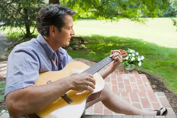 Man playing guitar outdoors Stock Image