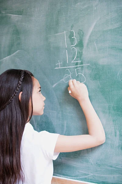 Meisje schrijven op blackboard — Stockfoto