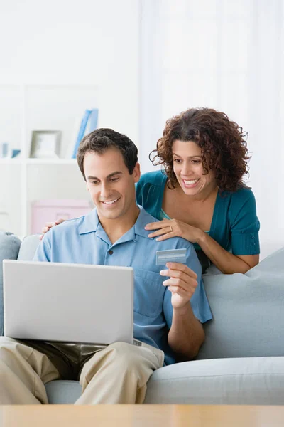 Пара використовує ноутбук з кредитною карткою — стокове фото