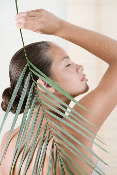 Mulher segurando folha de palma — Fotografia de Stock