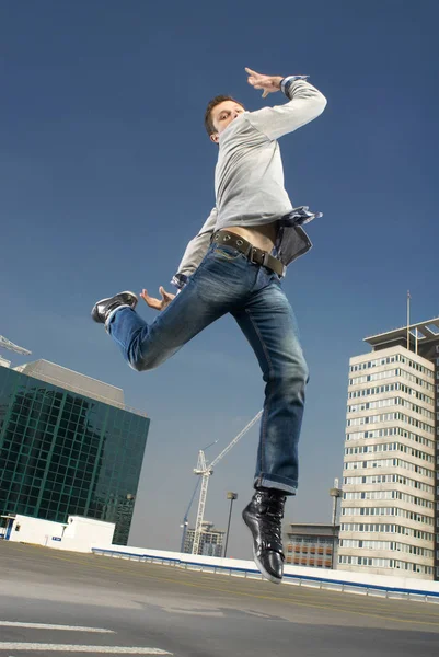 Мужчина танцует на городской крыше — стоковое фото