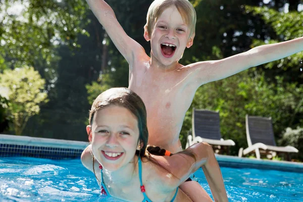 Menina e menino brincando na piscina — Fotografia de Stock