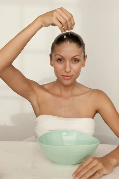 Woman dripping water into bowl — Stock Photo, Image