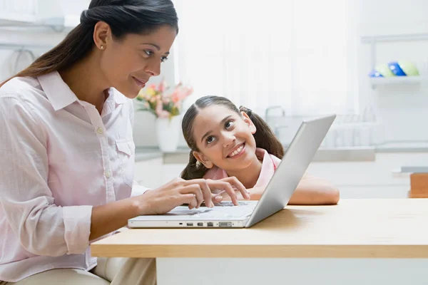 Äiti ja tytär käyttävät kannettavaa tietokonetta — kuvapankkivalokuva