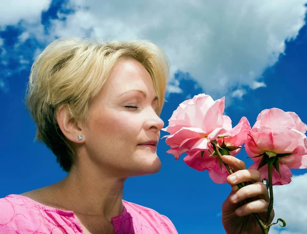 Mulher Cheirando Rosas Fundo Céu Azul — Fotografia de Stock