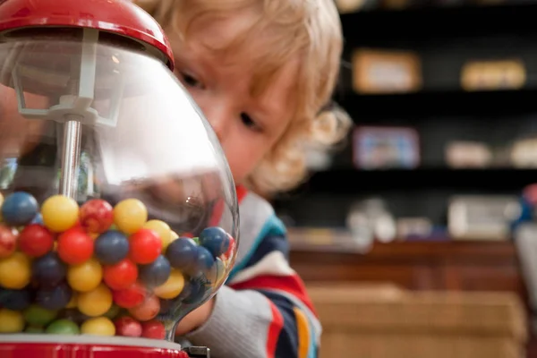 Boy taking colorful gums from plastic jar — Stock Photo, Image