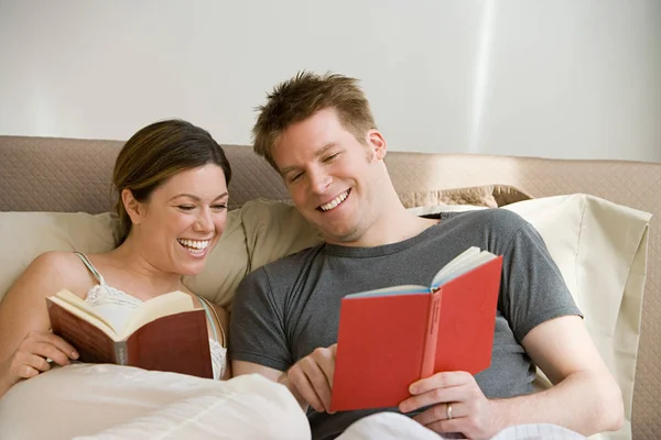 Pareja leyendo en la cama — Foto de Stock