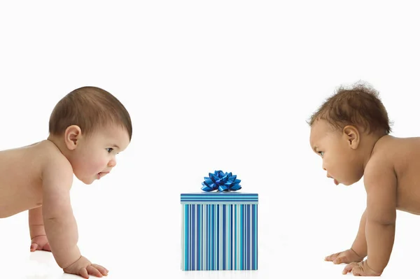 Два младенца с подарочной коробкой — стоковое фото