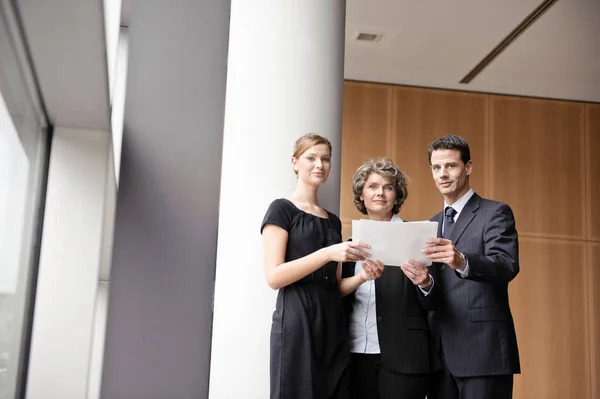Ludzie biznesu, stojąc z dokumentami — Zdjęcie stockowe