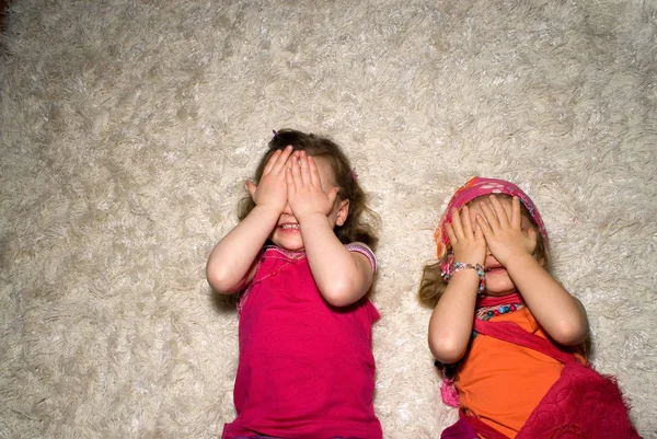 Tytöt makaa matolla ja sulkeutuvat silmät — kuvapankkivalokuva