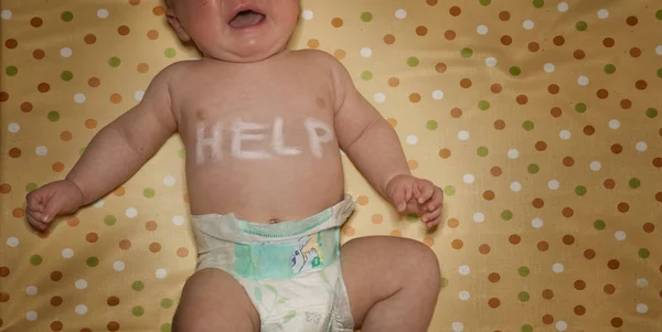 Recién nacido con palabra ayuda escrita en el pecho — Foto de Stock