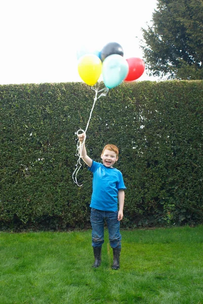 Junge hält Ballons in der Hand — Stockfoto