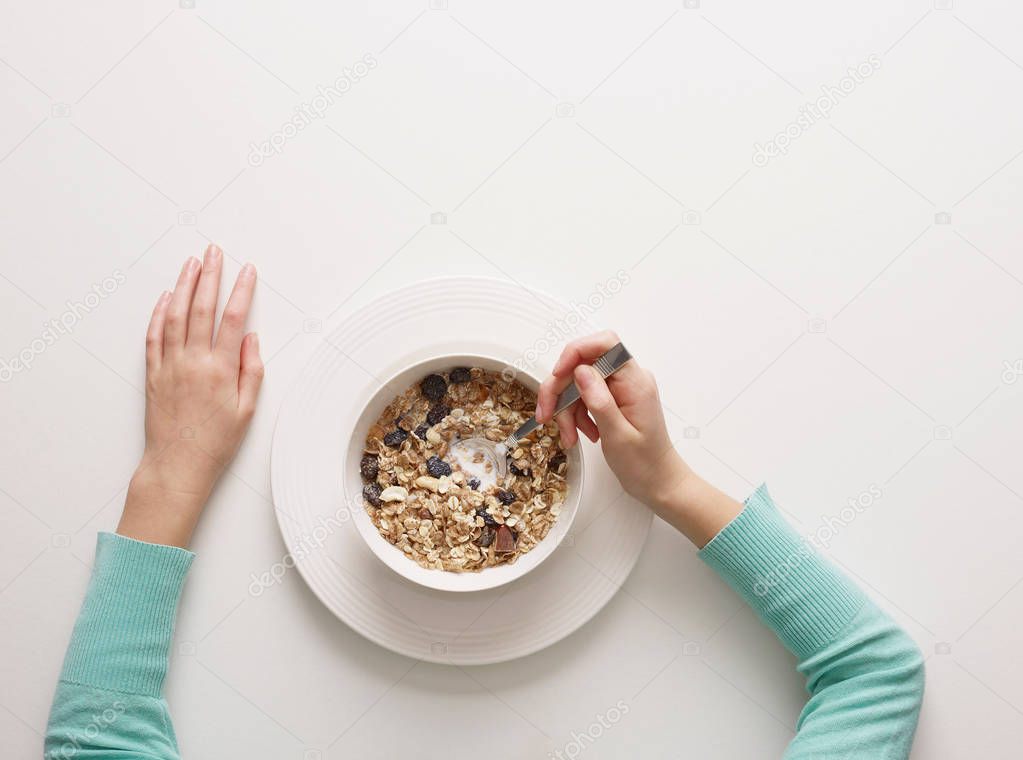 Hands by bowl of cereal isolated on white background