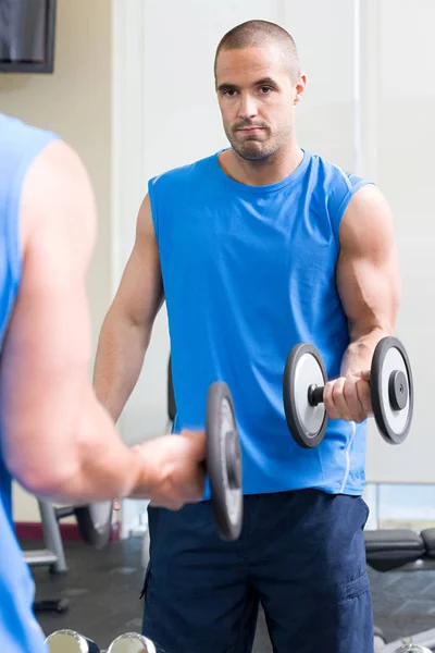 Hombre con mancuerna en el entrenamiento — Foto de Stock