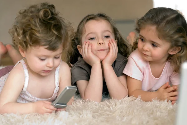 Three laying girls and mobile phone — Stock Photo, Image