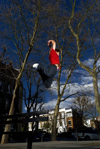 Hombre saltando sobre el banco — Foto de Stock