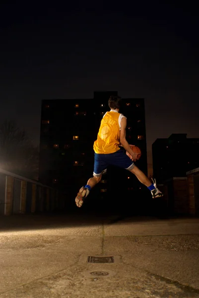 Jogador de basquete pulando com bola — Fotografia de Stock