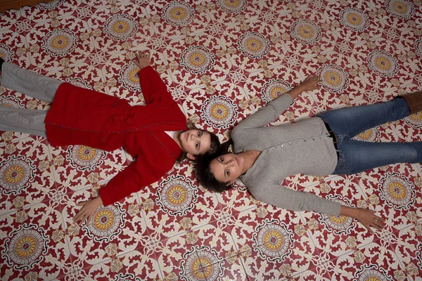 Nainen ja tytär makaamassa lattialla — kuvapankkivalokuva