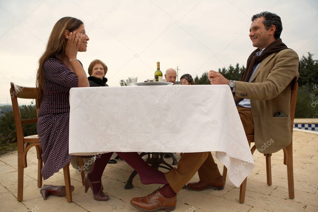 Woman flirting with man under table