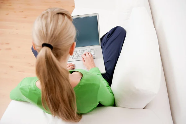 여자는 소파에 앉아 노트북을 사용 하 여 — 스톡 사진