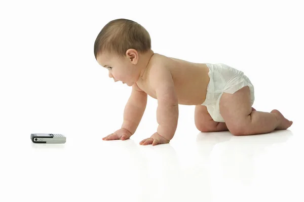 휴대 전화를 향해 크롤 링 하는 아기 — 스톡 사진