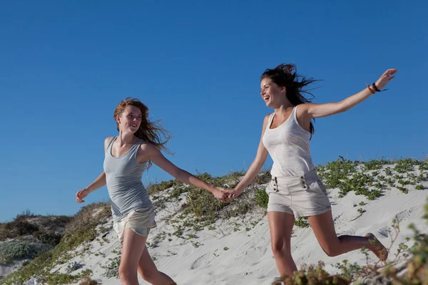 Meninas correndo na praia arenosa — Fotografia de Stock