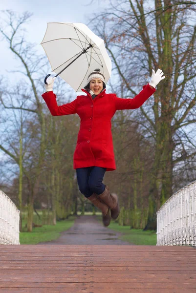 Kvinna i röd jacka med paraply — Stockfoto