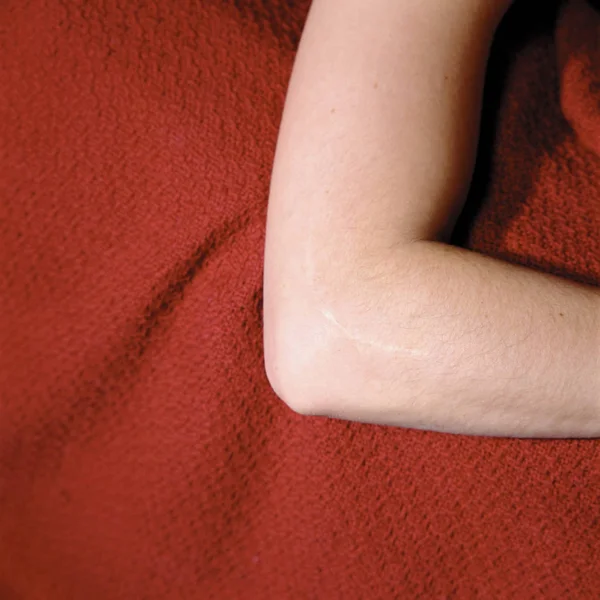 Vista Cortada Braço Feminino Cobertor Vermelho — Fotografia de Stock