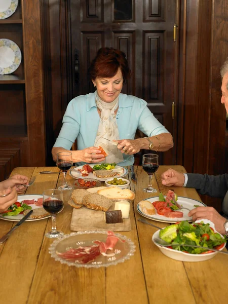 家族と一緒に昼食を食べている年配の女性 — ストック写真