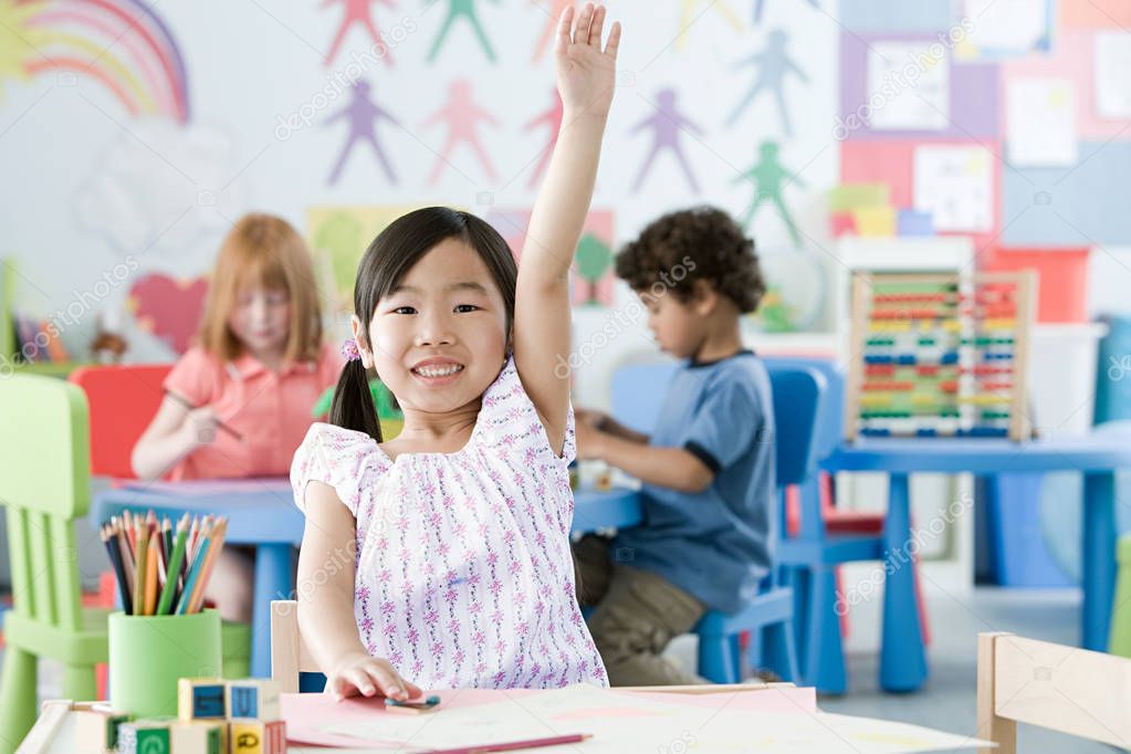 Girl raising arms in classroom 