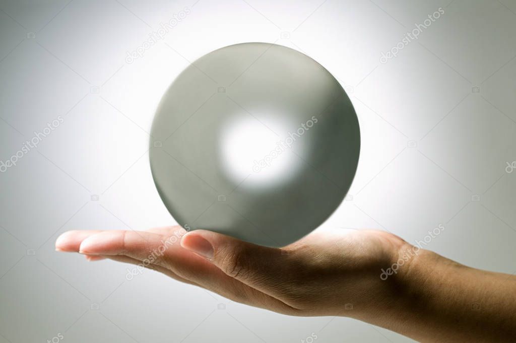 cropped shot of person holding crystal ball on white background