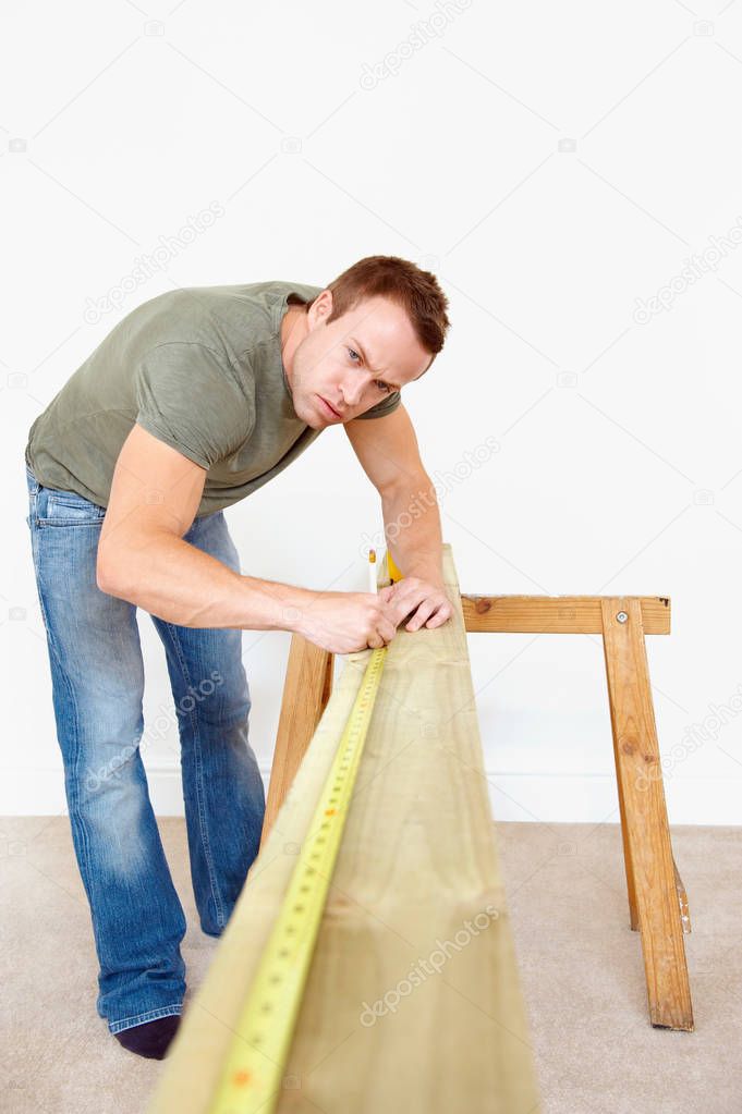 Man measuring wooden plank