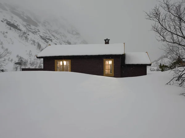 Berghütte Auf Schneebedecktem Hügel Mit Beleuchteten Fenstern — Stockfoto