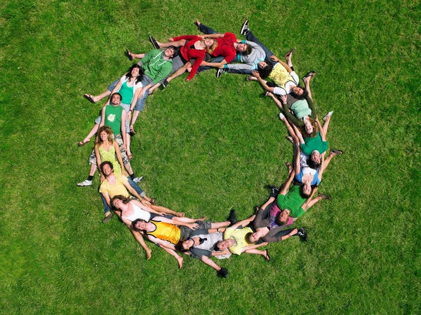 Grupa Ludzi Leżących Trawie Kręgu — Zdjęcie stockowe