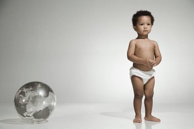 Toddler standing near a globe clipart