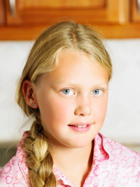 Young girl in kitchen looking at camera clipart