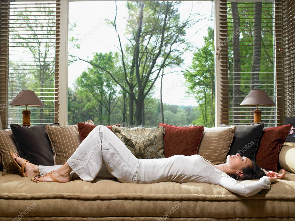 Woman sleeping on sofa in living room