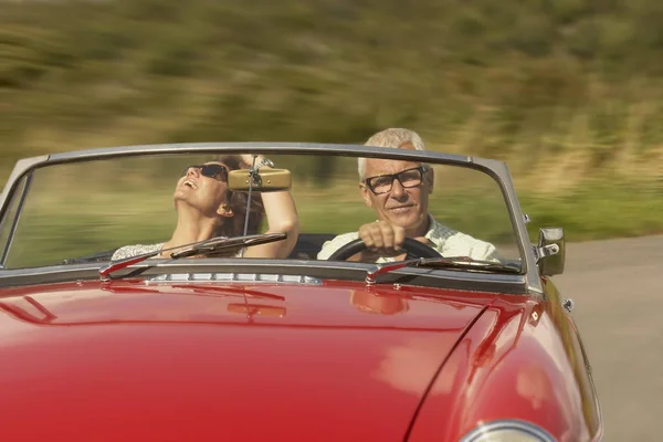 Pareja de mediana edad en coche deportivo — Foto de Stock