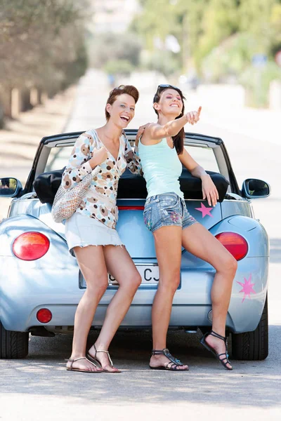 Women laughing by convertible car — Stock Photo, Image