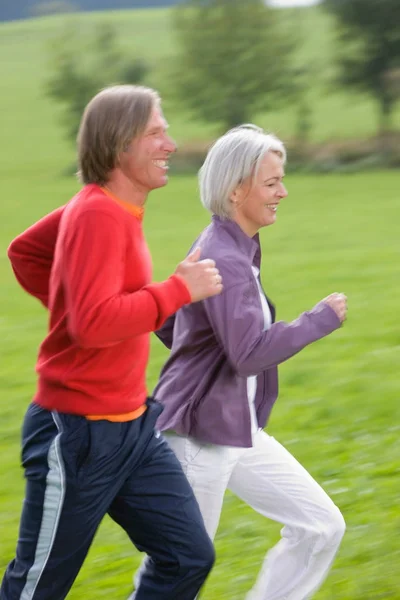 Mature couple running — Stock Photo, Image