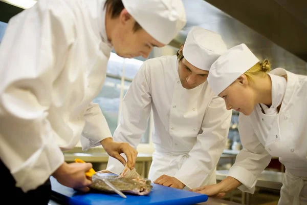 Drie Chefs Fileren Een Vis — Stockfoto