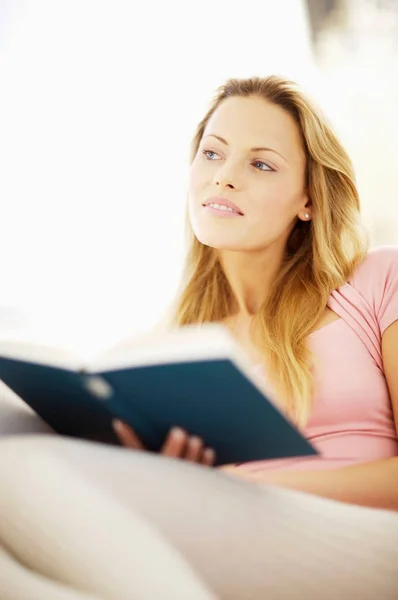 Mujer leyendo libro en sofá —  Fotos de Stock