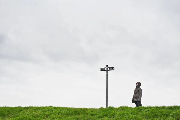 Frau schaut auf Wegweiser — Stockfoto