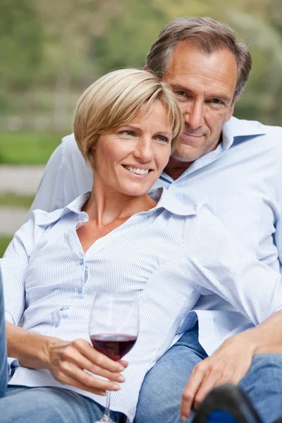 Пара середнього віку, що сидить поруч на відкритому повітрі — стокове фото