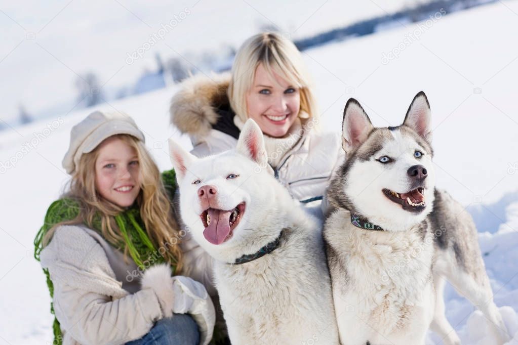 woman with daughter and huskies