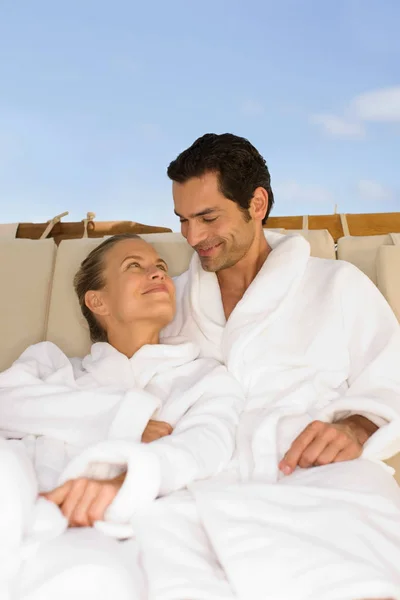 Couple sitting in bathrobes — Stock Photo, Image