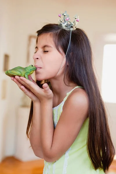 Dziewczyna ubrana w crown Całowanie zabawki żaba — Zdjęcie stockowe
