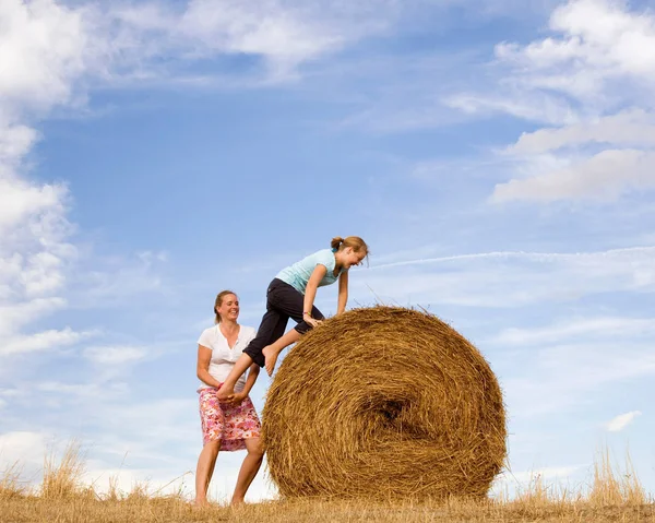 Mère Aidant Fille Grimper Balle Foin Sous Ciel Bleu — Photo