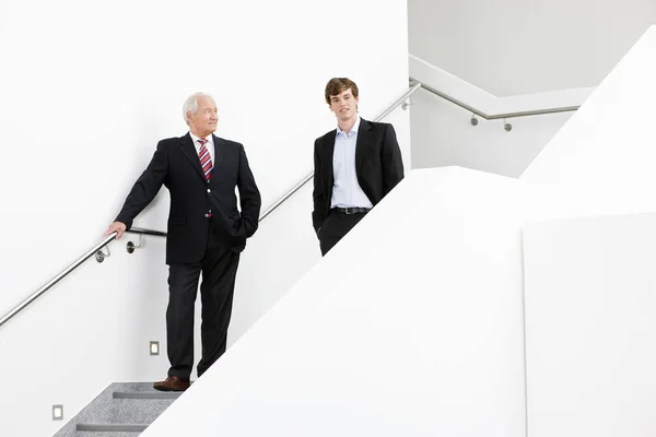 Два бизнесмена спускаются по лестнице — стоковое фото