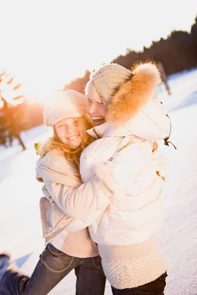 Vrouw met dochter knuffelen in de winter — Stockfoto